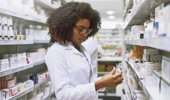 Pharmacist looking at prescription bottle 